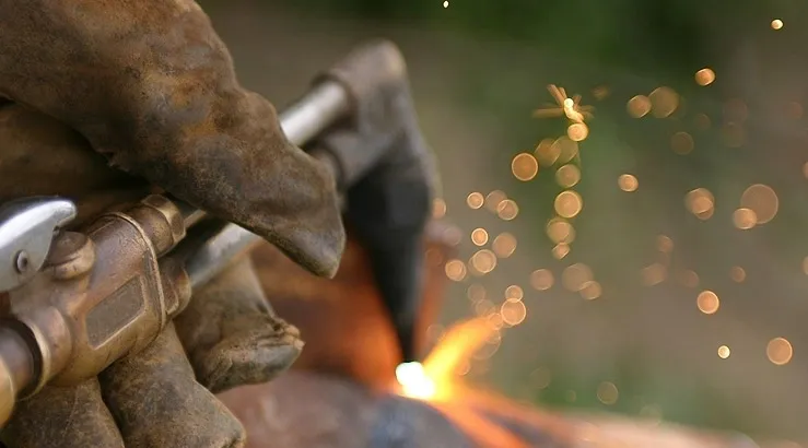 A person using an angle grinder to cut metal.