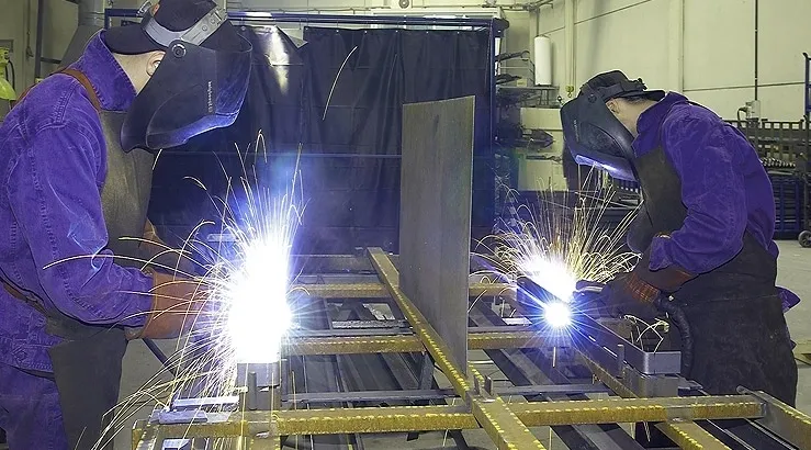 A person welding metal on top of a table.