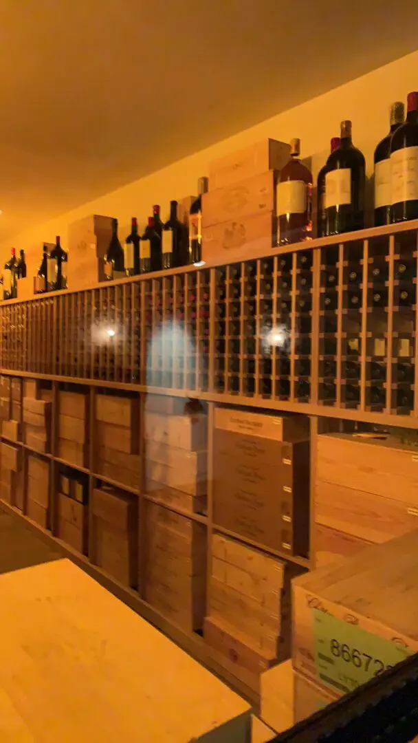 A wine cellar with many bottles of wine on the wall.