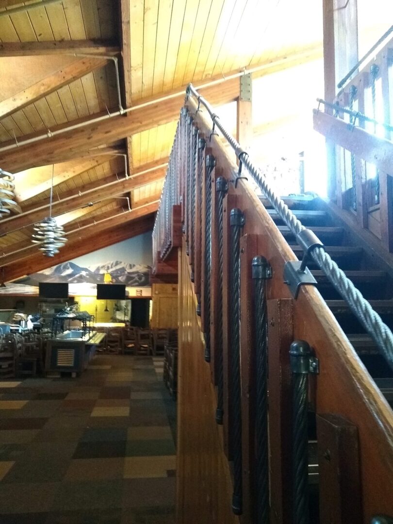 A wooden staircase with metal railing in the middle of an indoor area.