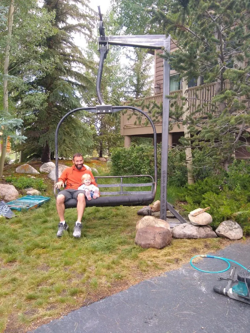 A man sitting on top of a chair lift.